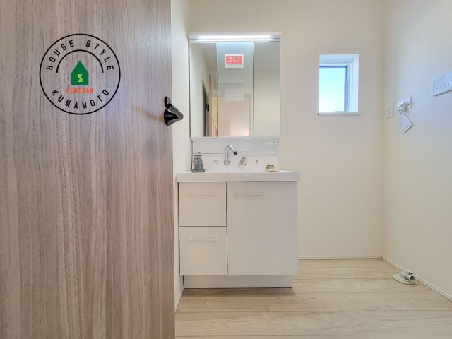 合志市須屋群窪第1-2棟（1号棟）の独立洗面台|毎日使うものだから清潔な空間を保ちたい水回り。洗面にはそんな願いを解消させてくれる収納アイデアが満載です。三面鏡の裏側にはキャビネットが現れ小物から背の高い物まで収納できます。