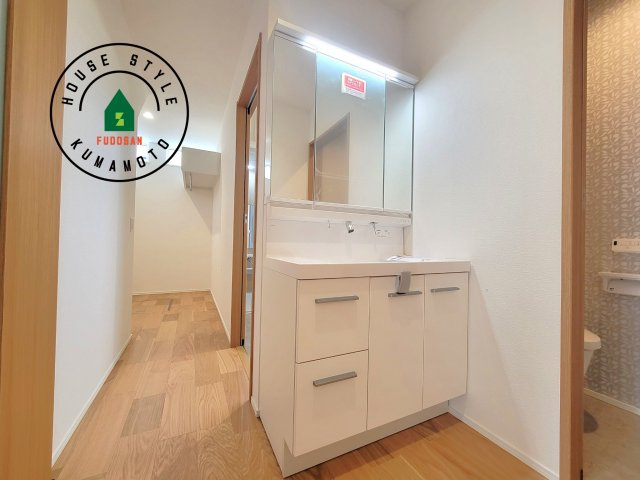 熊本市中央区薬園町第1-2棟（1号棟）の独立洗面台|毎日使うものだから清潔な空間を保ちたい水回り。洗面にはそんな願いを解消させてくれる収納アイデアが満載です。三面鏡の裏側にはキャビネットが現れ小物から背の高い物まで収納できます。