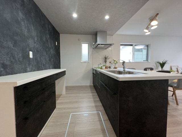 福生市福生　新築戸建全3棟のキッチン|キッチンには備え付けのカップボードが標準でついています。キッチンと色合いも統一されて収納豊富な設備。