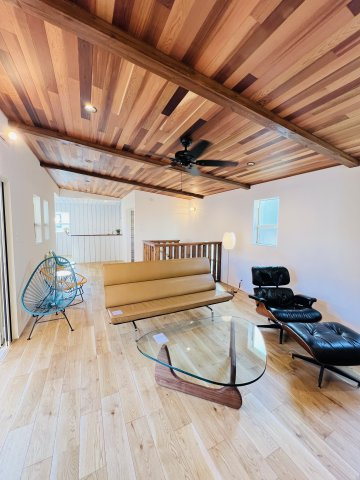 Beach Style House in茅ヶ崎の居間・リビング|無垢の床材と木板天井が演出する、まるでログハウスのような心地よさ。