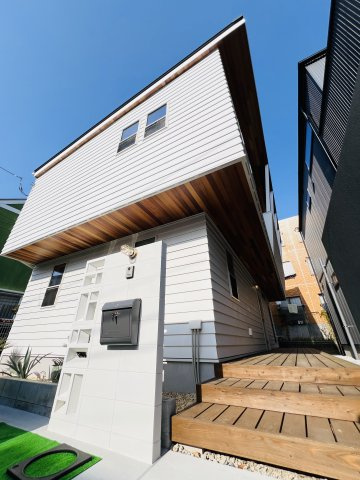 Beach Style House in茅ヶ崎の外観|白いラップサイディングに、あたたかみある木目の軒天井。