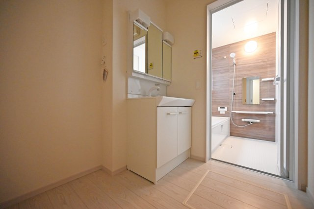 テラシエ上大市5丁目新築一戸建て│4LDK+駐車1台可の独立洗面台|1階洗面室に入ってすぐの内観写真です。900mm幅のシャンプードレッサーを導入しており、広々と使用できます。十分な明るさのある2照明を採用し、朝支度もスムーズに進みます。