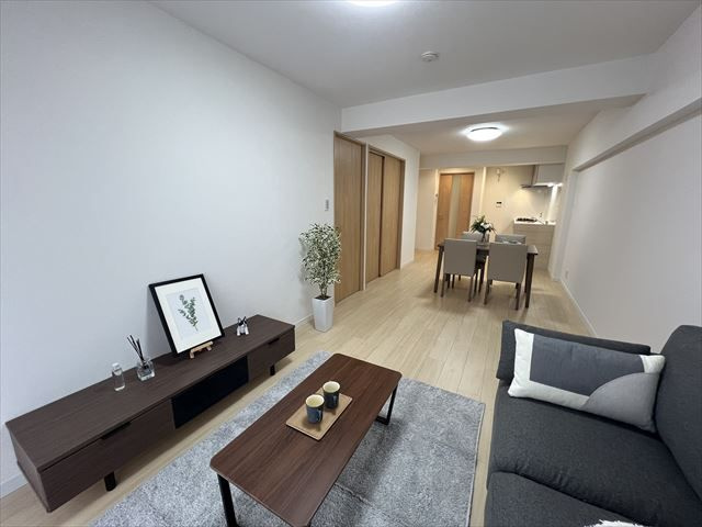 【居間・リビング】 | ローレルハイツ高宮 | バルコニーに面した明るいリビングは、壁付タイプのキッチンで空間をいっそう広く！
大きなダイニングテーブルも、ソファやテレビも自由にレイアウト。
ご家族に合わせてインテリアを考えるのが楽しくなりますね