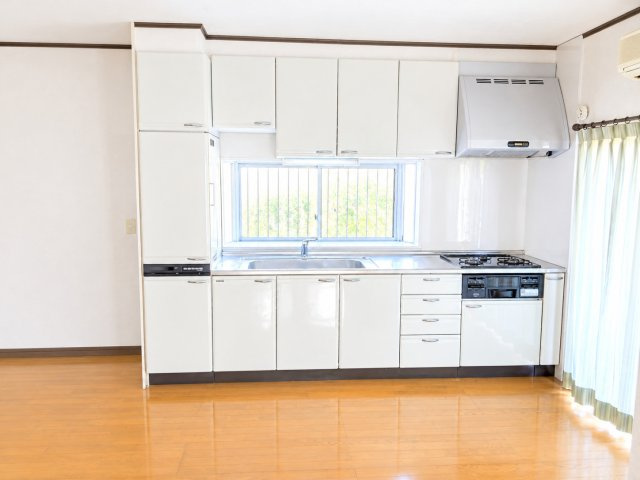 熊谷市小八林　中古戸建のキッチン|出窓もあるのたっぷりの上下収納と便利な小分け引き出しを備えたシステムキッチン。シンク前の小窓から自然光が差し込む、明るく清潔感のある空間です。