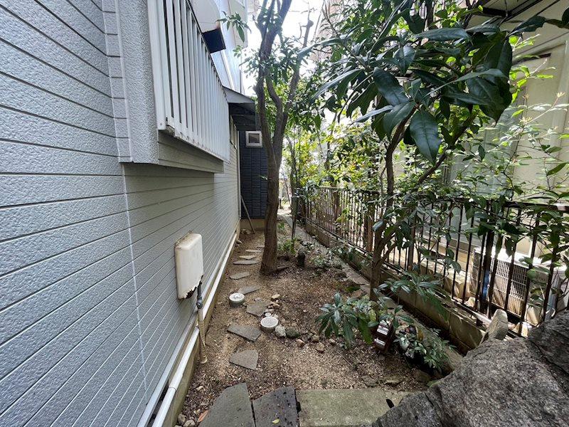 甲陽園山王町 中古戸建の庭|西側の裏庭スペースにも飛び石を配置し遊び心をくすぐります。