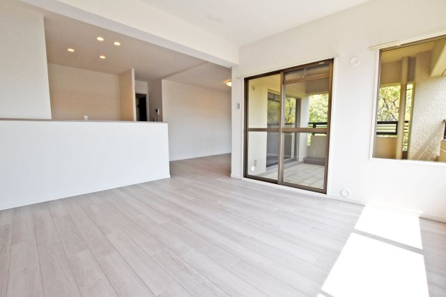 愛宕山ビューハイツの居間・リビング|間口いっぱいの大きな窓から陽ざしが入り明るいLDK空間です。リビングとダイニングのゾーニング分けがしやすく、それぞれの空間作りを楽しめます。