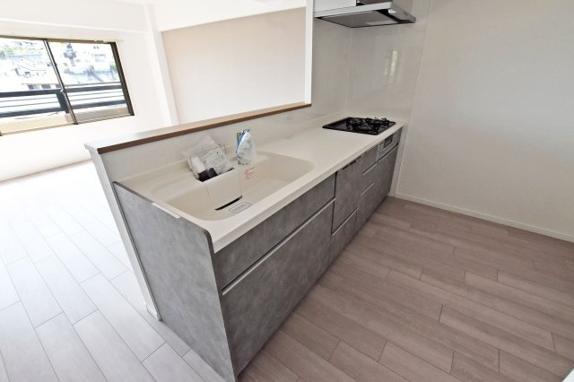 愛宕山ビューハイツのキッチン|清潔感のあるキッチンは家族の会話弾む対面キッチンで、ゆったりリビングダイニングを一望できます。