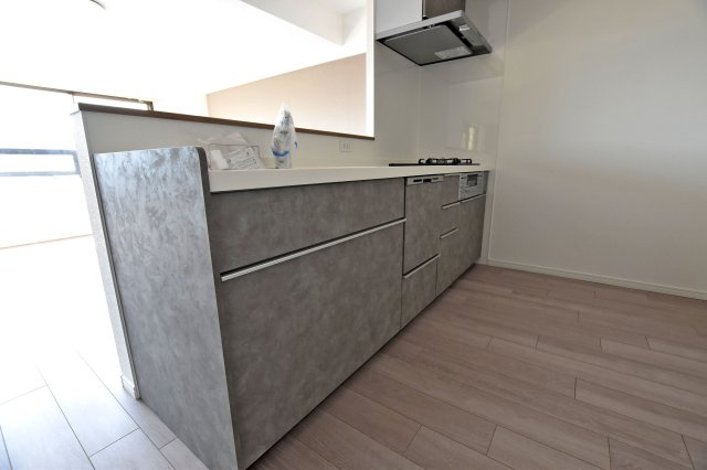 愛宕山ビューハイツのキッチン|収納豊富×機能性充実のシステムキッチン。３口コンロとグリル付き、食洗機などを完備し、快適なお料理時間をサポートしてくれます。