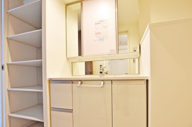 愛宕山ビューハイツの独立洗面台|３面鏡の明るい洗面化粧台で、毎朝の支度もはかどります。鏡裏と洗面台下にも収納があり、日用品やスキンケア用品などもしまえてすっきりとした空間を保つことができます。