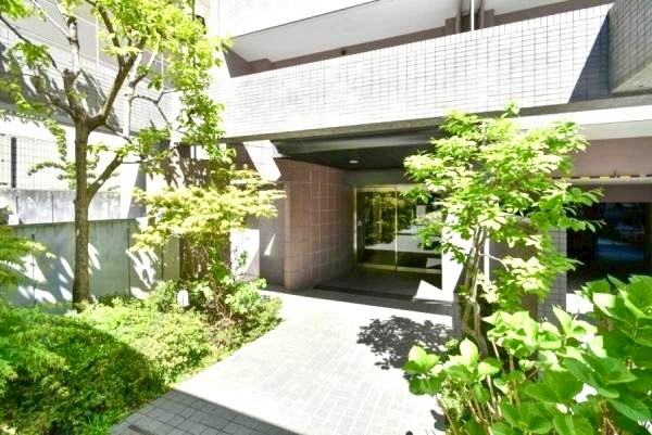 横浜高砂パークハウスのエントランス|石材やタイルをあしらった高級感のあるファサード、丁寧に手入れされた植栽も魅力のひとつです。