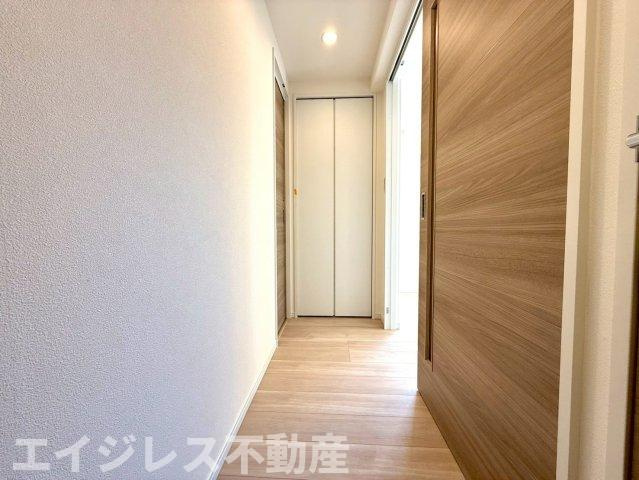 夕陽ヶ丘ニュースカイマンションの玄関|廊下にはランドリースペースが備わっており、便利な棚も完備。洗濯用品やタオルを整理整頓でき、すっきりとした空間で効率よく家事がこなせます。収納力が高く、快適に使用できます。