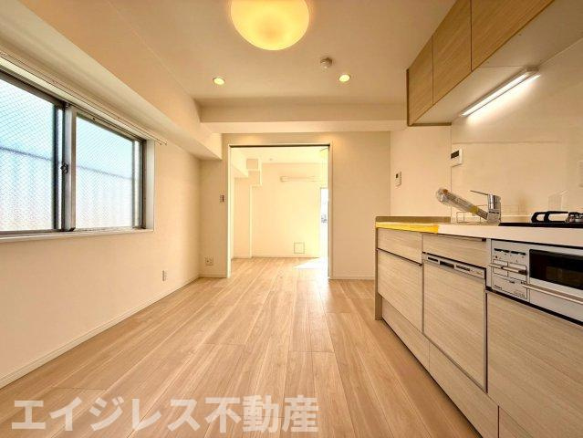 夕陽ヶ丘ニュースカイマンションの居間・リビング|6.7帖のダイニングキッチンはコンパクトながら機能的。食洗機・浄水器付きで家事効率も良好。南西向きの心地よい陽光が差し込む、明るく快適な暮らしを実現します。