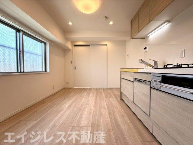 夕陽ヶ丘ニュースカイマンションの居間・リビング|6.7帖のダイニングキッチンはコンパクトながら機能的。食洗機・浄水器付きで家事効率も良好。南西向きの心地よい陽光が差し込む、明るく快適な暮らしを実現します。