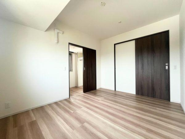 デュオヒルズ大分中島の洋室|やさしい木目調のフローリングと白を基調とした壁が、明るく清潔感のある空間を演出。扉の色合いが空間に程よいアクセントを加え、シンプルながらもスタイリッシュな印象の洋室です！