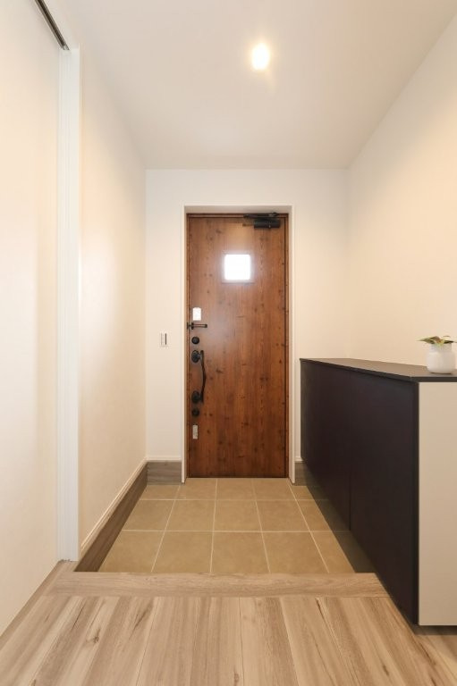 塔野一丁目の玄関|木の扉が印象的な玄関。
温かみのある素材感と自然光が調和し、帰宅するたびにほっと落ち着く空間を演出します。