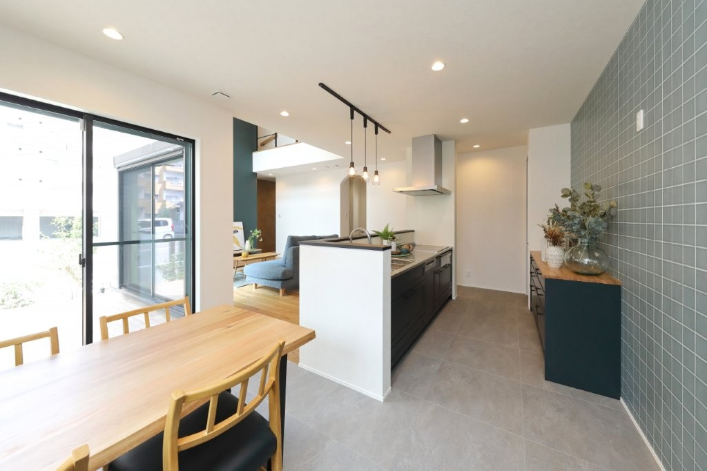 穴生一丁目（2期）の居間・リビング|キッチンを一段下げたスキップフロア設計。ダイニングの家族とキッチンの目線がぴったり合います。