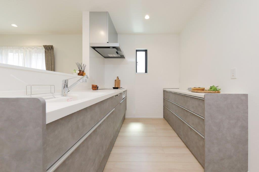 湯川新町一丁目（5期）のキッチン|おしゃれなグレージュのキッチン。食洗機付きで家事も快適！カップボードも備え付けられています。