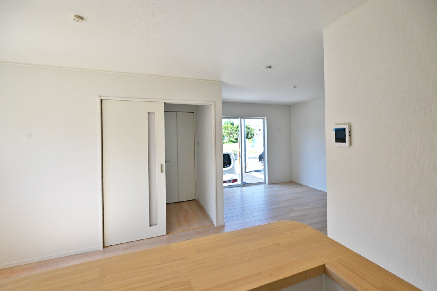 クレイドルガーデン北王子町新築一戸建て全8区画│4LDK+並列駐車2台可の居間・リビング|1階LDKをキッチン前から撮影した内観写真です 。 未就学児も含む4人家族がゆとりをもって過ごすには十分の1棟です。