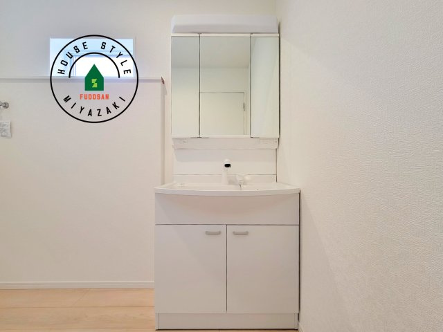 宮崎市赤江第5-2棟（1号棟）の独立洗面台|毎日使うものだから清潔な空間を保ちたい水回り。洗面にはそんな願いを解消させてくれる収納アイデアが満載です。三面鏡の裏側にはキャビネットが現れ小物から背の高い物まで収納できます。