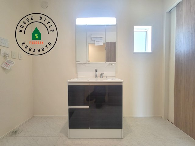菊池市泗水町吉富第2-4棟（4号棟）の独立洗面台|毎日使うものだから清潔な空間を保ちたい水回り。洗面にはそんな願いを解消させてくれる収納アイデアが満載です。三面鏡の裏側にはキャビネットが現れ小物から背の高い物まで収納できます。