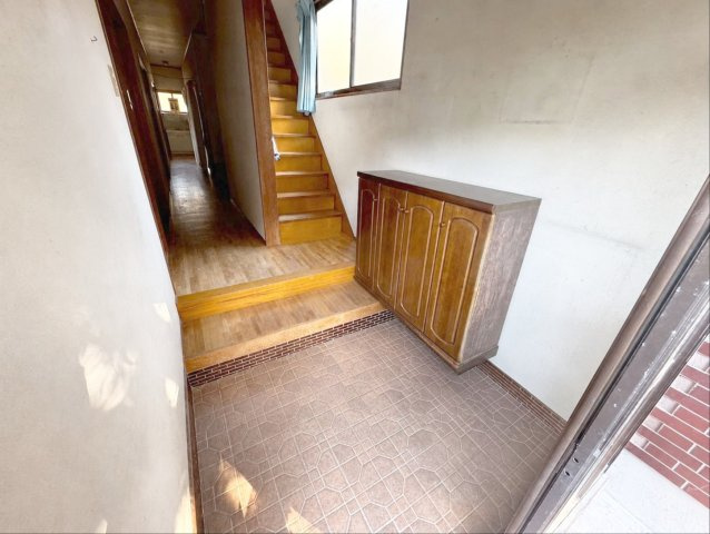 飯塚市鯰田　中古戸建の玄関|玄関入ってすぐの様子です！階段、廊下へとつながる動線！
（※AI加工により荷物を消去しています）