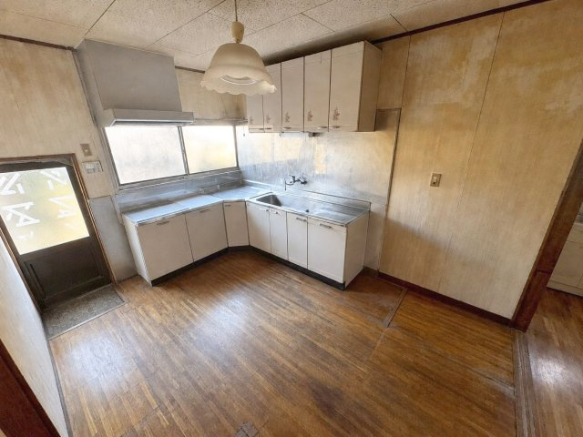 飯塚市鯰田　中古戸建のキッチン|勝手口付きのキッチン！家事動線が良くて便利ですね！
（※AI加工により家具・荷物を消去しています）