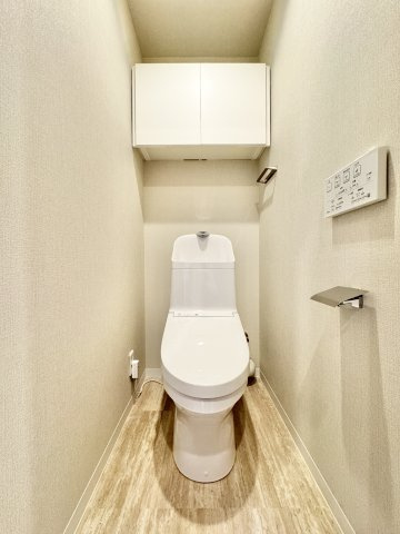 成子坂壱番街のトイレ|白を基調とした収納棚付きトイレです。