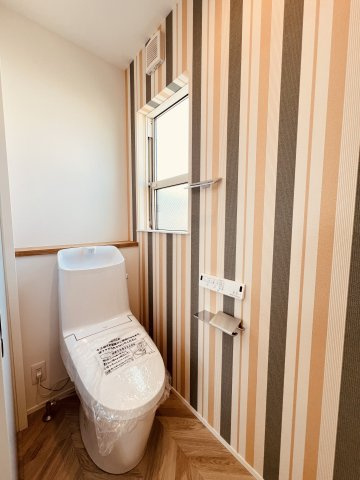 湘南Surfer's Houseのトイレ|遊び心あるストライプ柄で、トイレ空間もデザイン性高く。小さな空間も抜かりなくお洒落に。