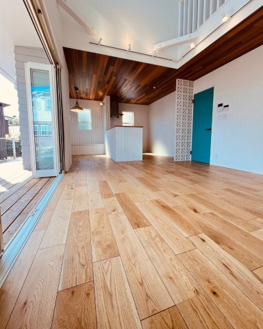 湘南Surfer's Houseの居間・リビング|開放感あふれる吹き抜けリビングと木目が美しい勾配天井。空間そのものがインテリア。