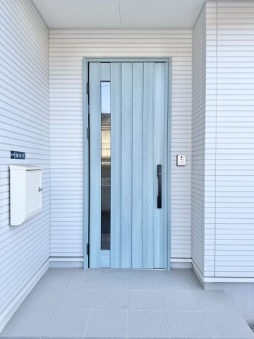 中央区中沢町の玄関|淡いターコイズブルーの玄関ドアが目を引きです。
玄関ポーチの屋根が雨風を防いでくれます。