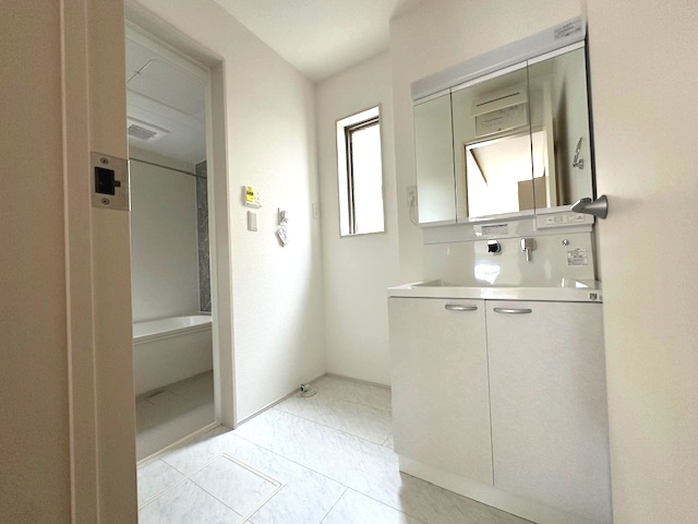 【新築戸建】　いわき市郷ケ丘5期の脱衣所|三面鏡の洗面台です。鏡の裏には収納スペースがあり、小物などをすっきり片付けることができます