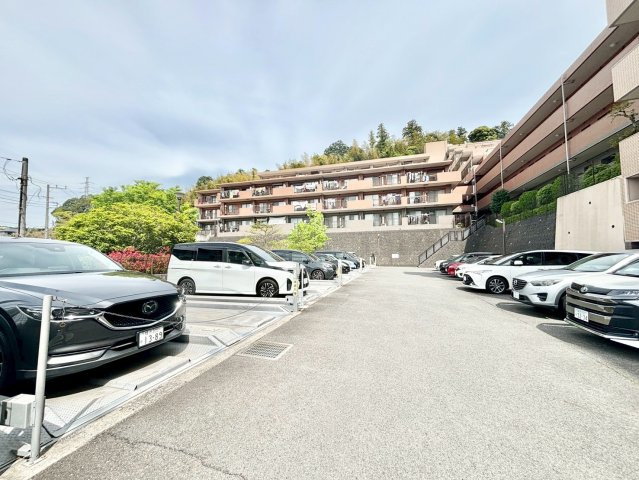 藤和ハイタウン本郷台の駐車場|2000年に竣工した藤和ハイタウン本郷台は、外観は落ち着いたブラウン系の7階建てタイル貼りで、共用部にはオートロック、宅配ボックス、キッズルーム、集会室、プレイロット、提供公園が設けられています。