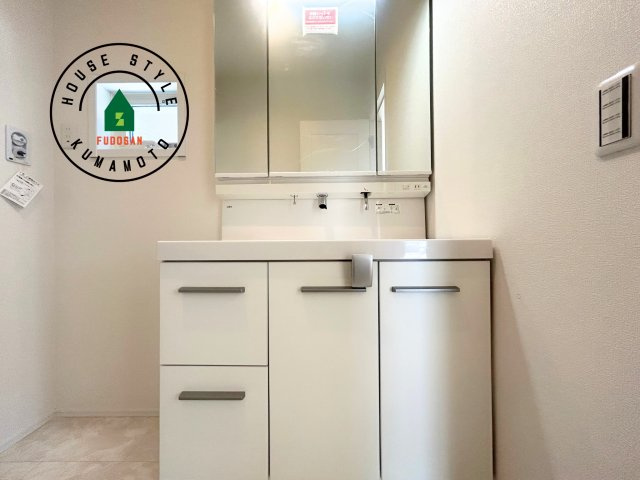 熊本市西区池亀町第1-2棟（2号棟）の内観：施工例|毎日使うものだから清潔な空間を保ちたい水回り。洗面にはそんな願いを解消させてくれる収納アイデアが満載です。三面鏡の裏側にはキャビネットが現れ小物から背の高い物まで収納できます。