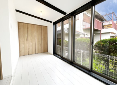 【居間・リビング】 | 伏見区桃山紅雪町　中古戸建 | LDKの隣にあるこちらのスペースも、4枚の掃き出し窓から光が差し込み風が十分に通ります。たっぷりの収納が完備されています。