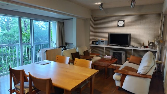 富士急川奈別荘地の居間・リビング|左手は急な坂です。木が茂っていますがその奥には海があります。