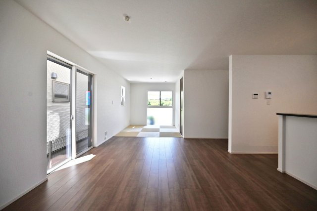 ファーストタウン安倉北1丁目新築一戸建て│2SLDK+駐車1台可の居間・リビング|1階LDKをダイニング側から正面に撮影した内観写真です 。 未就学児も含む4人家族がゆとりをもって過ごすには十分の1棟です。