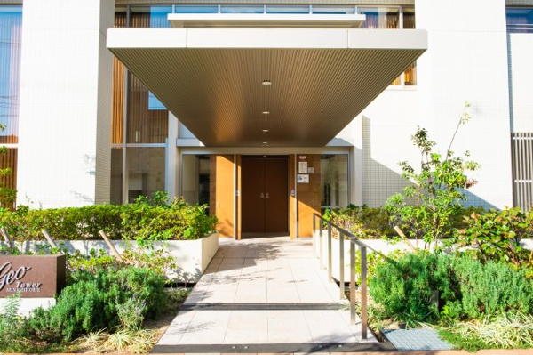  | 【エントランス外観】大きな庇と豊かな緑が印象的！阪急の人気ブランドである「ジオ」のロゴがお出迎え。