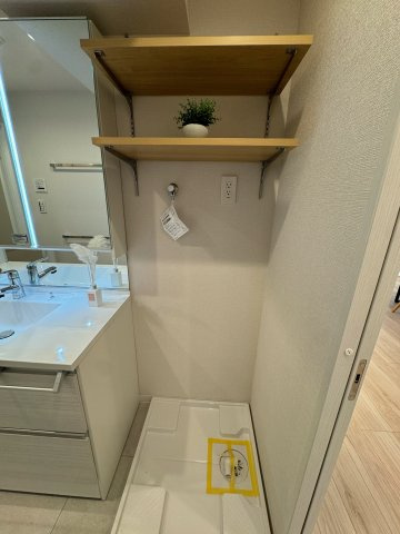 西戸山タワーホウムズサウスタワーのランドリースペース|洗面台のすぐ横にランドリースペースがあり忙しい朝でもスムーズに洗濯可能です。上部には棚が設けられておりタオルや洗濯洗剤など収納することができすっきりと整理できそうです。