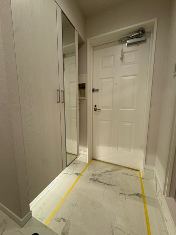 西戸山タワーホウムズサウスタワーの玄関|白を基調とした清潔感のある玄関。大切なゲストを爽やかにもてなします。玄関を入った右手側にカウンターがあり荷物置き場や、お花やお気に入りの雑貨などを飾るインテリアスペースとしてもご活用いただけます。