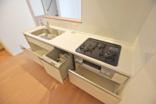 尼崎市浜田町５丁目新築一戸建て│3LDK+駐車1台可のキッチン|食洗機や3口コンロを備えた、毎日の家事を支えるシステムキッチン。足元まで使える引き出し収納で、調理器具やキッチン用品もすっきりまとめられます。