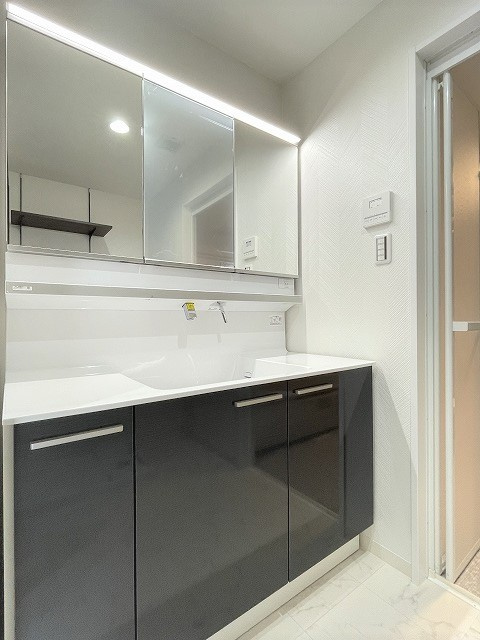 ヴェルディ広駅前ツインタワーの洗面所|横幅の広い洗面は、3面鏡になる鏡が付いています。鏡の後ろは収納になっています。