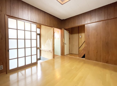【洋室】 | 上京区御前通下立売上る三丁目東入三助町　中古戸建 | 【洋室6帖】北側にある扉を開けると2階への階段があります。右側の階段下は収納スペースとなっています。