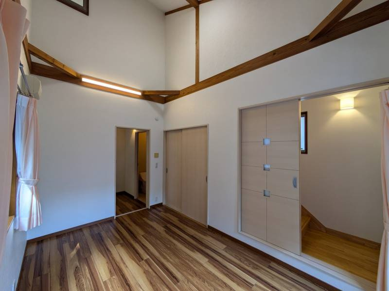 高知市福井町　　中古一戸建ての洋室|2階部分まで吹き抜けた贅沢な天井高。おしゃれな梁が空間のアクセントに。