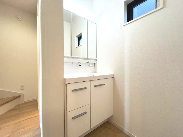 熱田区五番町2期　新築戸建　1号棟の独立洗面台|毎日の身だしなみを快適にする機能的な洗面化粧台です。明るい照明と清潔感のあるデザインで、朝の準備から一日の終りのリフレッシュタイムまで心地よくお使いいただけます。