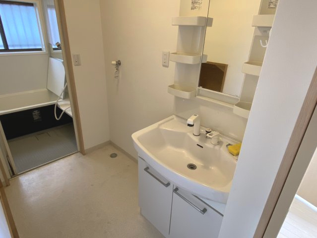 西条市大町　中古住宅の独立洗面台|清潔感溢れるサニタリースペース。内装リフォームにより床や壁も綺麗に整えられ、毎日の洗顔や脱衣が心地よい時間に。洗濯機置き場との動線も良く、機能的な配置が多忙な家事のフットワークを軽くしてくれます。