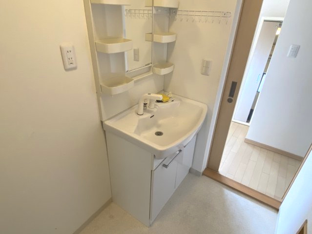 西条市大町　中古住宅の独立洗面台|白で統一された爽やかな洗面室。リフォーム済みの新しい設備が、日々の生活の質をワンランク引き上げます。脱衣スペースにもゆとりがあり、家族の着替えやタオルもすっきり収まる、暮らしやすさを考えた設計。