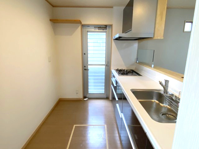 西条市大町　中古住宅のキッチン|リフォームで一新されたモダンなキッチン空間。食洗機完備で手荒れの悩みも解消し、家事時間の短縮を叶えます。広々としたワークトップでお子様と一緒にお菓子作りを楽しむなど、食卓の彩りが広がる設計。