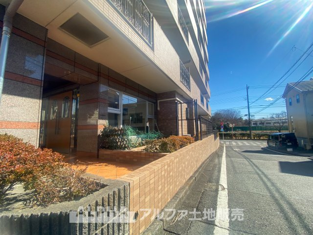 モナーク聖蹟桜ヶ丘の外観|陽光が差し込む明るいエントランス。タイル張りのアプローチが上品な雰囲気を演出し、植栽が住まいに彩りを添えます。日々の暮らしに安心感と快適さをもたらす住環境。