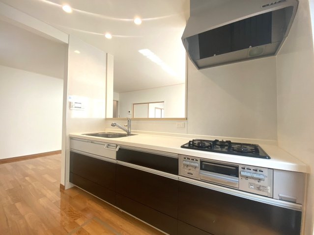 伏見区日野岡西町のキッチン|料理に便利な3口コンロ。キッチン扉は高級感がありならがらも清潔感あるブラウン系の配色です。現地（2024年6月）撮影