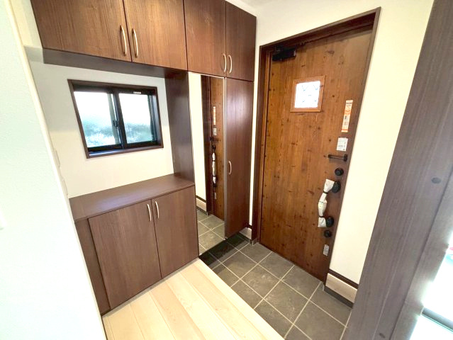 西伊敷4丁目　新築戸建て①の玄関|姿見付きの下駄箱収納です。家族分の靴もたっぷり収納できます。